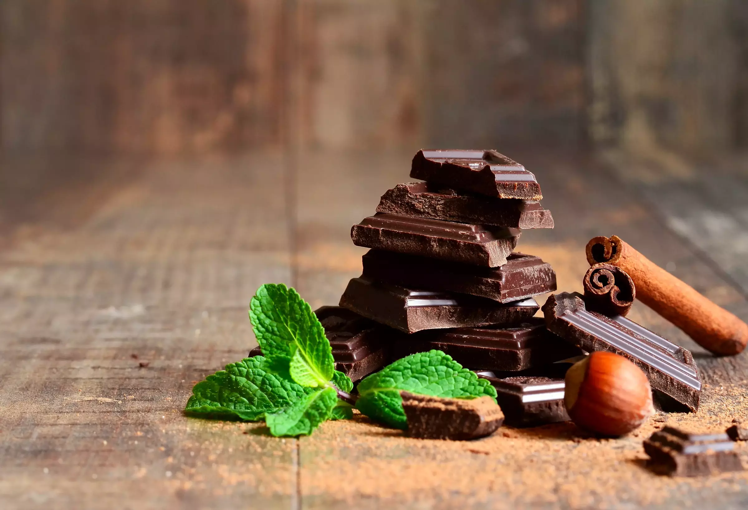 Stack of chocolate slices with mint leaf,hazelnut and cinnamon.